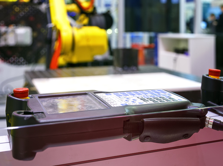 Digital Controller For Robot in Factory against the background of blurred yellow robotsの写真素材