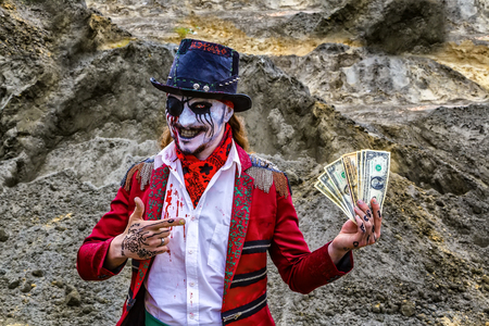 one-eyed pirate robber with eye patch and blood stains holds dollars, burning eye.の写真素材