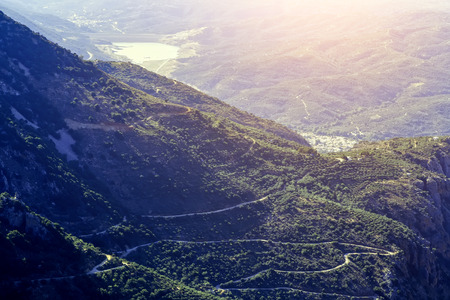 slope of the mountain near the Lassithi plateau with views of the lake and the village , the setting sun, the evening. Crete Greece. Sun valley of Greece. Beautiful Lassithi Plateau on island of Crete, Greece.の写真素材