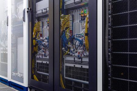 Close up server rack with LED indicator, internet wires, optic cables inside under meshed door....