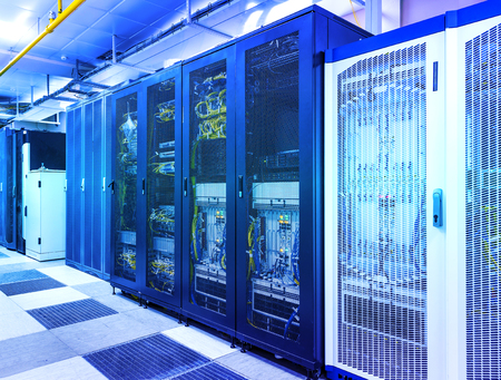 Server room with control modules in racks datacenter. Exchanging cyber data and connections in rows of server hardware concept. Technological background under blue toningの写真素材