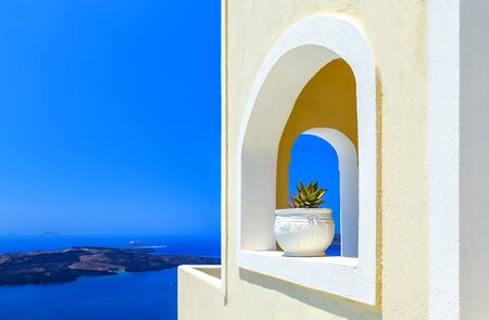 Greece Santorini island in Cyclades, traditional detail sights of colorful flowers with pots and caldera sea in the backgroundの写真素材