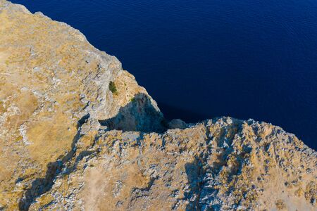 Aerial top view of sea waves hitting rocks on the beach with turquoise sea water. Amazing rock cliff seascape in Portuguese coastline. Drone shot.の写真素材