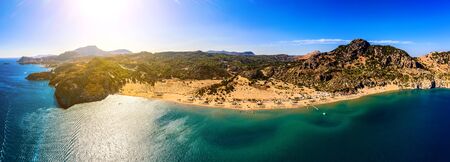 panorama of the famous resort beach tsampika with rows of sunbeds and umbrellas, view of the mountains, the island from a birds eye view, from droneの写真素材