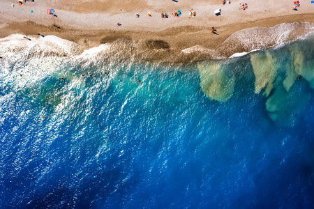 texture of the sea with clear turquoise water and bottom top view with the drone. iridescent yellow...