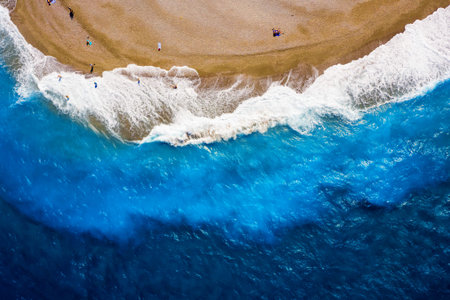 texture of the sea surf with white waves, turquoise water and sandy shoreの写真素材
