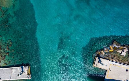 waterfront port Mandraki Rhodes island, clear turquoise water, rocks and bottom in clear water, top view, bird's eye viewの写真素材