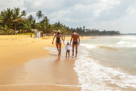 Mother and children go home from the beach. Happy family resting on the sunset background. Sun kissed child.の写真素材