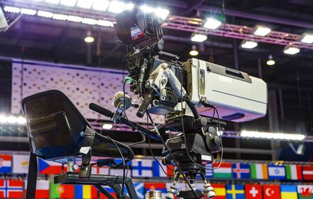 operator's seat of a huge professional video camera for broadcasting sports events in 4K on background of flags championship participants.の写真素材