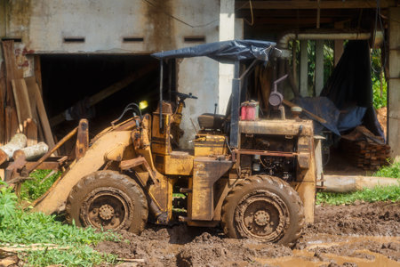 Asian sawmill in the tropics, mud, puddles, tractor, Sri Lanka day Sunny