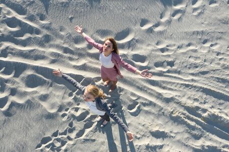 Two stranded business womens seeking help standing on the white sand of desert with pleading prayer handsの写真素材