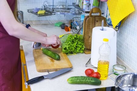 Happy young couple have fun in modern kitchen indoor while preparing vegetables food for lunchの写真素材