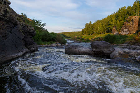 Ural Mountains. Rocks and rocky rifts on a mountain river in summer. View on valley and the river Iset with rocky banks.の写真素材