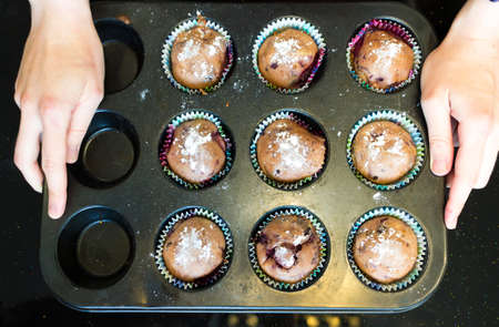 baked cupcake cakes in a muffin tin and eggshells isolated with shadows on a white background, high angle view from above, copy spaceの写真素材