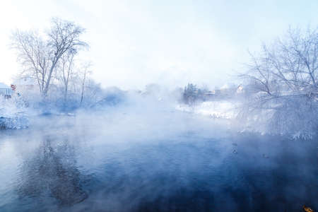 River in the fog. Forest by the river in hoarfrost, hoarfrost. Background water of the river and the forest on the shore in fog.の写真素材