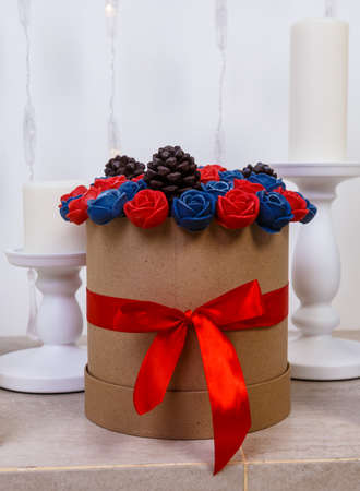 hatbox with bouquet of chocolate roses standing in the fireplace among candles.の写真素材