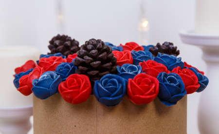 basket with chocolate flowers roses on a white background among candles, fireplace, sweet gift, edible flowers.の写真素材