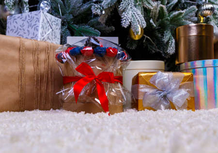 round box bouquet with flowers roses on the background of gift boxes with ribbons at Christmas treeの写真素材