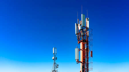 Technology on top of the telecommunication GSM 4G tower antenna, transmitter , blue sky, white clouds.の写真素材