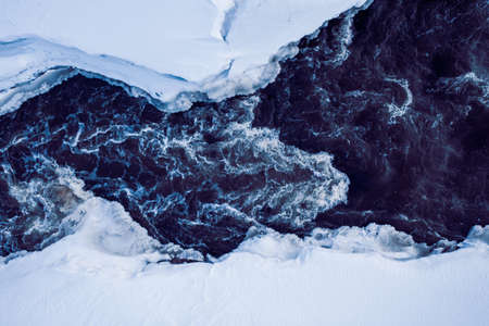 texture of water in thawed ice, snow in winter, the view from the drone.の写真素材