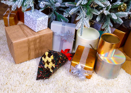 Christmas gifts under the Christmas tree red and wooden toys brick wall, in foreground bouquet of chocolate flowersの写真素材