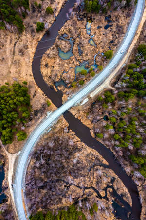 winding road next to river among forests and swamps, the nature of the Urals, the view from the drone.の写真素材