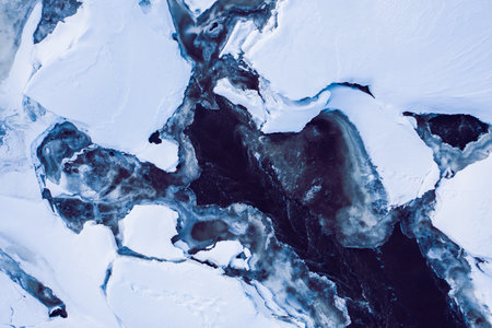 texture of water in thawed ice, snow in winter, the view from the drone.の写真素材