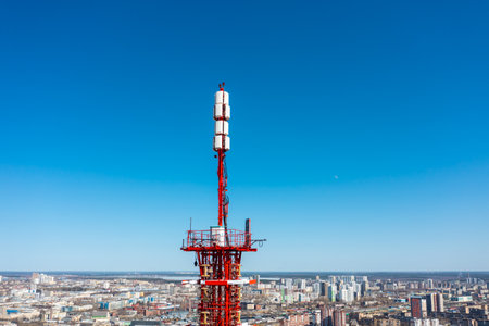 Telecommunication tower of 4G and 5G cellular. Macro Base Station. 5G radio network telecommunication equipment with radio modules and smart antennas mounted on metal on blue sky background.の写真素材