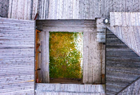 wooden village house in Russia of the 19th century, outbuildings and a yard with tools, a view vertically down from drone.の写真素材