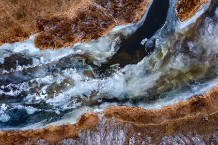 Aerial view of a blue and green river with snow and crushed ice during an ice drift in winterの写真素材