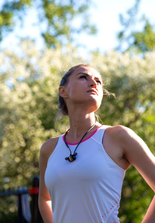 Portrait of sporty woman relax posing at summer forest. The concept of wellness and outdoor activity