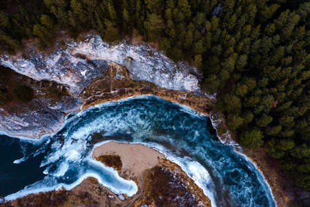 texture of frozen river with transparent ice, with bends and islands, rocks, forest, birds-eye view, nature of autumn.の写真素材