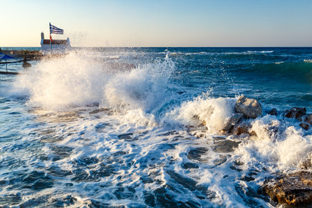 Beautiful Sea Landscape with Waves Breaking on a Sandy and Rocky Beach. Waves on Background. Summer time in Rhodes, Greece. rocks on the coast of blue sea on a sunny summer dayの写真素材