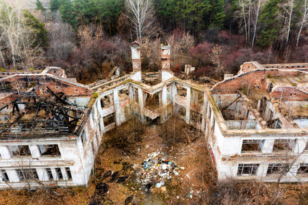 abandoned hospital building after the fire among the forest and greenery, autumn landscape. A birds-eye view from drone.の写真素材
