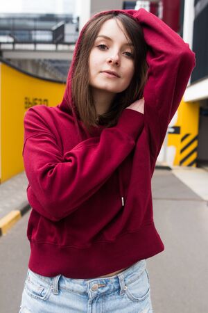 big eyes, sweet girl in burgundy hoodie, smiling and looking at youの写真素材
