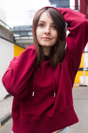 big eyes, sweet girl in burgundy hoodie, smiling and looking at youの写真素材