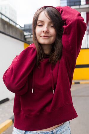 big eyes, sweet girl in burgundy hoodie, smiling and looking at youの写真素材