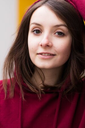 big eyes, sweet girl in burgundy hoodie, smiling and looking at youの写真素材