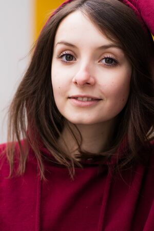 big eyes, sweet girl in burgundy hoodie, smiling and looking at youの写真素材