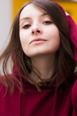 big eyes, sweet girl in burgundy hoodie, smiling and looking at youの写真素材