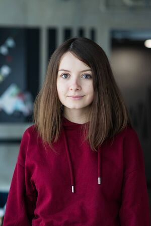 big eyes, sweet girl in burgundy hoodie, smiling and looking at youの写真素材