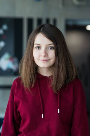 big eyes, sweet girl in burgundy hoodie, smiling and looking at youの写真素材