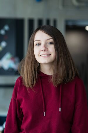 big eyes, sweet girl in burgundy hoodie, smiling and looking at youの写真素材