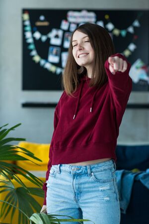 big eyes, sweet girl in burgundy hoodie, smiling and looking at youの写真素材