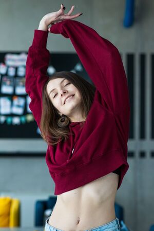 big eyes, sweet girl in burgundy hoodie, smiling and looking at youの写真素材