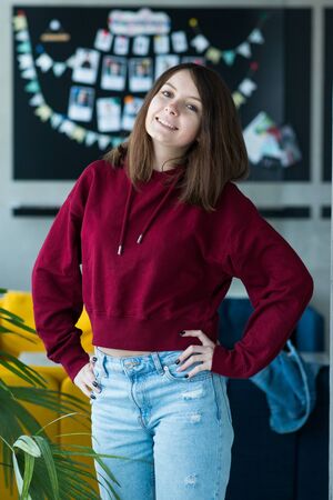 big eyes, sweet girl in burgundy hoodie, smiling and looking at youの写真素材