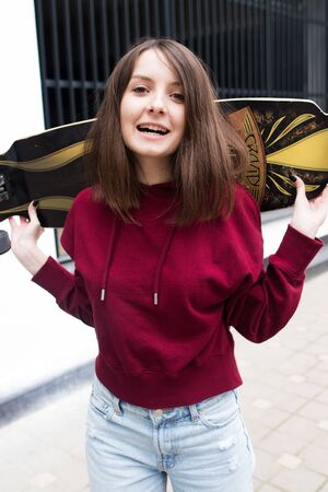 big eyes, sweet girl in burgundy hoodie, smiling and looking at youの写真素材