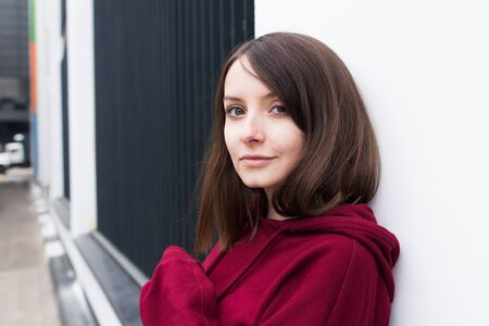 big eyes, sweet girl in burgundy hoodie, smiling and looking at youの写真素材