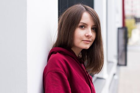 big eyes, sweet girl in burgundy hoodie, smiling and looking at youの写真素材