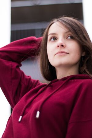 big eyes, sweet girl in burgundy hoodie, smiling and looking at youの写真素材